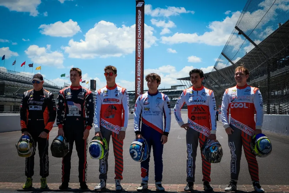 Six drivers lined up with their helmets at Indianapolis Motor Speedway